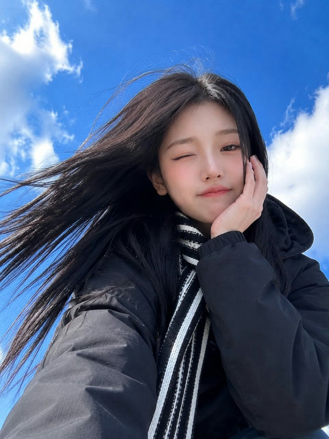 蓝天背景仰拍加油姿势东亚美女手机自拍 - AI图片提示词示例