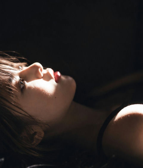 黑暗背景东亚女性电影感写实侧颜肖像 - AI图片提示词示例